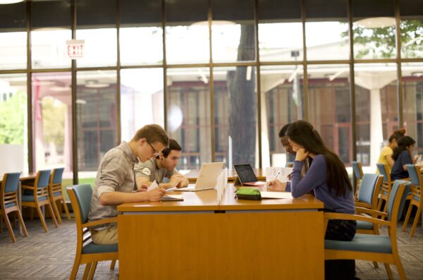 Students sit together at a table and study