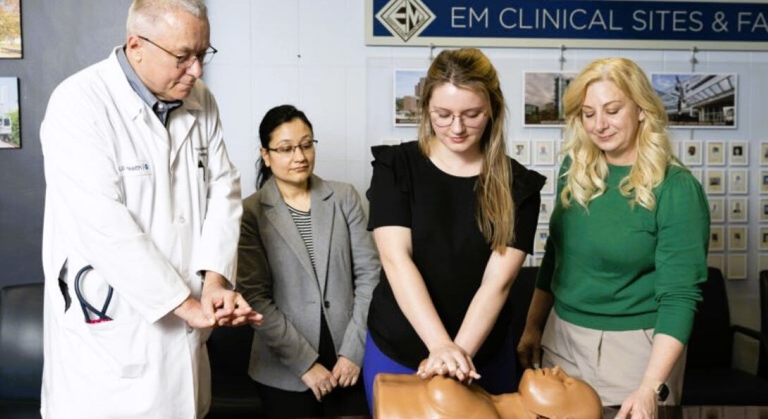 Physicians demonstrating CPR on mannikin