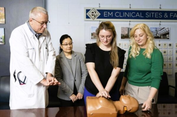 Physicians demonstrating CPR on mannikin