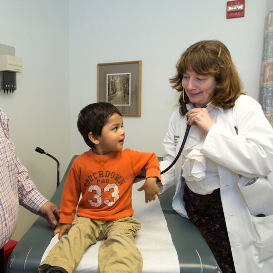 A doctor uses a stethoscope on a child patient