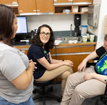 Dr. Erin Hickey, center, talks with patient Isaiah Menchaca and his mom, Josephine Alvarez, during a visit to the UI Health Lifespan Disability Clinic. (Photo: Jenny Fontaine/UIC)
                  