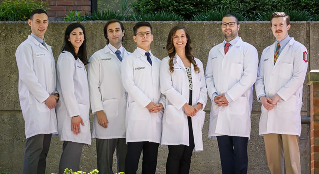 A group of doctors in white coats pose for a group photo