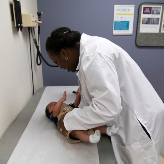 A doctor examines a baby on a clinic table