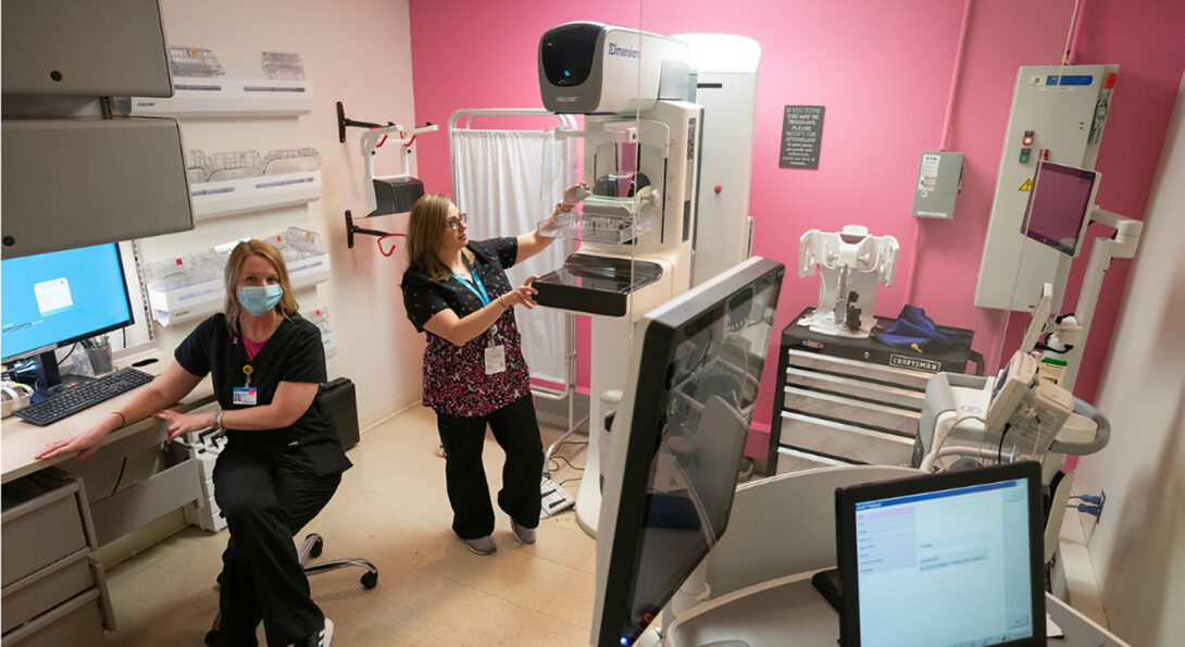 A radiology room with two staff members working