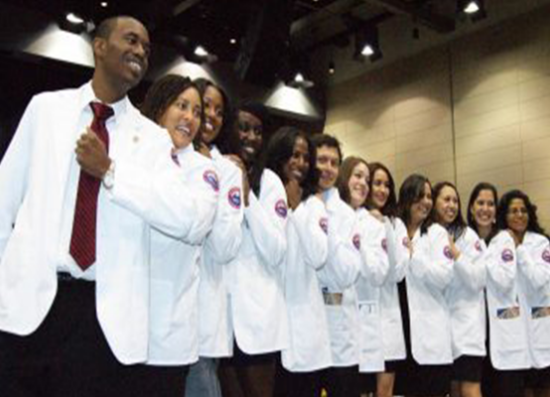 a large group of people standing in a line, showing off their white coats.