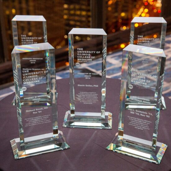 5 glass award trophies sitting on a table